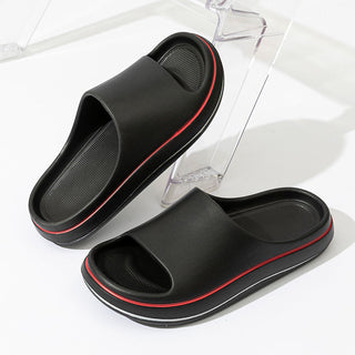 Sleek and stylish men's slippers with a bold red accent stripe, perfect for relaxing at home or around the house in modern comfort and fashion.