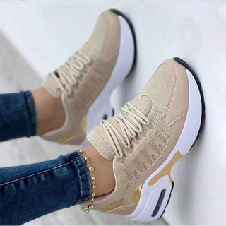 Stylish beige athletic sneakers with modern design, laced up for women's casual athleisure wear.