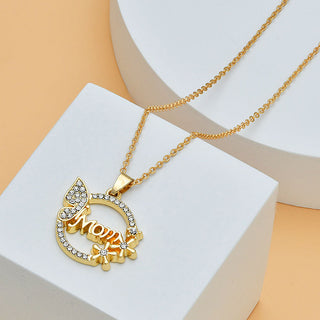 Elegant gold-toned necklace with diamond-encrusted heart-shaped pendant featuring the word "Mom" and a floral design, perfect for Mother's Day gift.