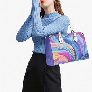 Stylish multicolored handbag with eye-catching abstract print, carried by a woman wearing a cozy blue turtleneck sweater.