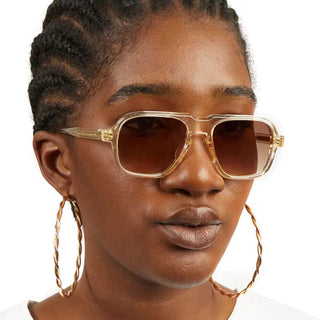 Vintage Oversized Sunglasses with Gold Frames and Lenses, Worn by a Young Woman with Braided Hair