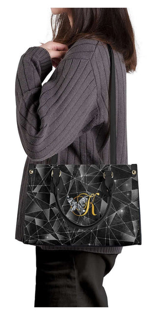Geometric Black Handbag: Stylish K-AROLE tote with intricate pattern and gold-tone hardware, complementing the trendy women's athleisure outfits.
