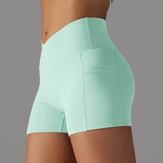 Comfortable mint green athletic shorts with side pocket design for active women's wear.