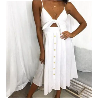 Elegant white sleeveless and backless summer dress with button details, displayed on a female model in a studio setting.