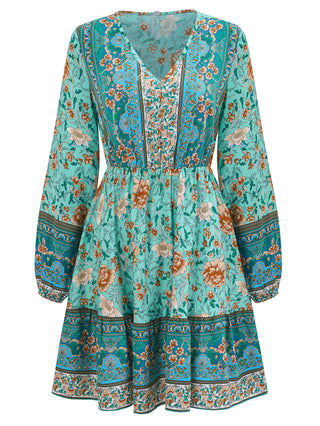 Elegant floral printed v-neck dress in vibrant teal color, featuring long sleeves and a flowing, knee-length silhouette set against a plain background.