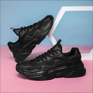 Sleek and sporty black sneakers with a textured mesh and leather upper, featuring a chunky sole for added comfort and support. These modern, stylish shoes are the perfect choice to elevate your casual outfit.