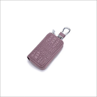 Stylish leather key holder with croc embossed pattern in lavender hue, featuring a zipper closure and a metal clip for easily attaching to bags or purses.