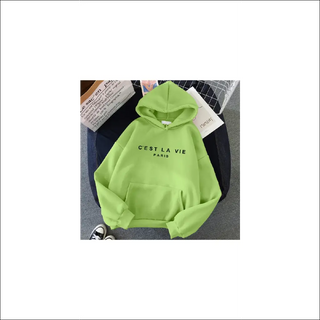 Vibrant green hoodie with "C'EST LA VIE PARIS" printed on the front. The hoodie is placed on a textured surface, creating an eye-catching contrast. The minimalist design and bold color make this a stylish and trendy sports top.