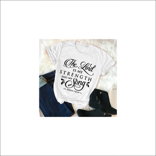 Fashionable white t-shirt with faith-based typographic design. The text reads "The Lord is my strength and my song" - a biblical quote from Psalm 118:14. The shirt features a distressed, vintage-inspired print aesthetic, complemented by a casual and relaxed style. This product is an example of trendy women's faith-based apparel that can be worn to express one's beliefs with a chic, modern touch.