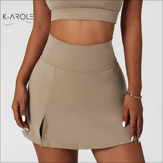 Ribbed one-shoulder beige yoga bra set with stretch and shockproof fabric, paired with a beige high-rise mini skirt, showcasing the K-AROLE brand logo.