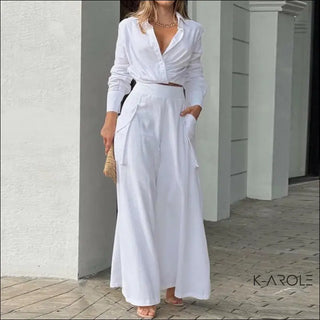 Elegant white linen dress with loose pockets and long sleeves, styled by model in modern setting at K-AROLE fashion store.